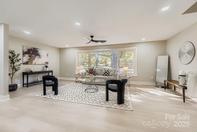 a living room with furniture a window and a flat screen tv