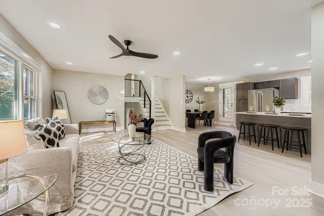 a living room with furniture a view of dining room and a large window