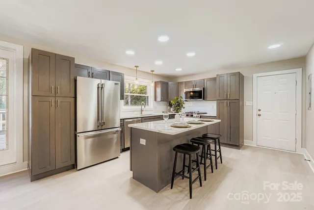 a kitchen with refrigerator and white cabinets