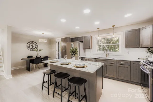 a kitchen with stainless steel appliances kitchen island granite countertop a sink and cabinets