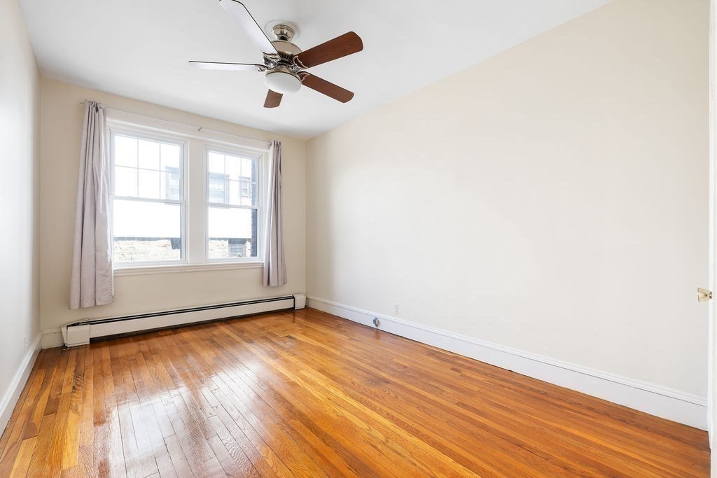 321 Tappan Street, Unit 2 Brookline, MA 02445 - Photo 17 of 25 an empty room with wooden floor and windows