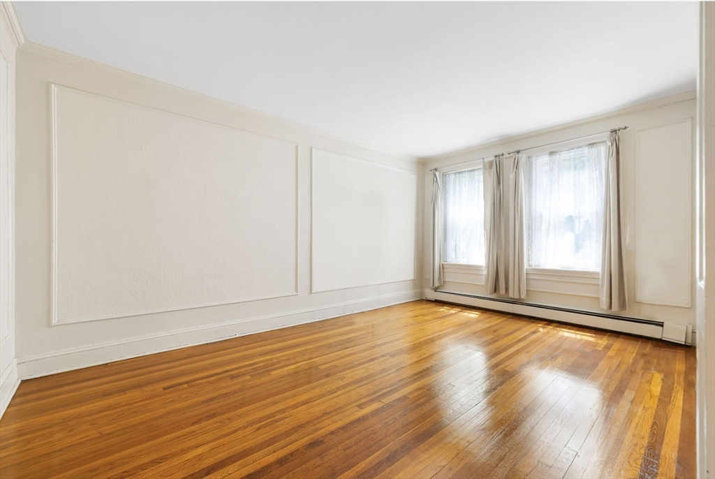 321 Tappan Street, Unit 2 Brookline, MA 02445 - Photo 4 of 25 a view of an empty room with wooden floor and a window