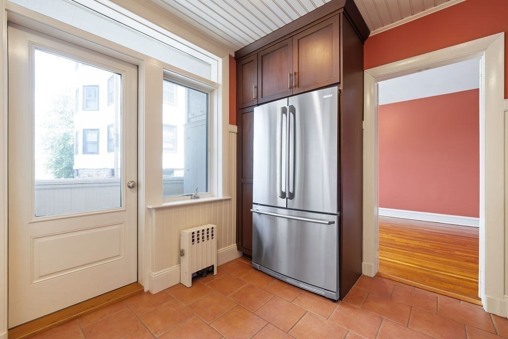 321 Tappan Street, Unit 2 Brookline, MA 02445 - Photo 7 of 25 a view of a refrigerator in kitchen and an empty room
