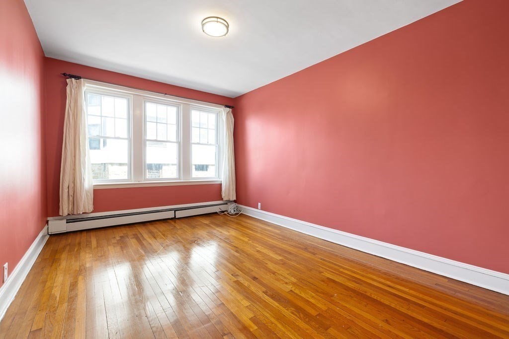 321 Tappan Street, Unit 2 Brookline, MA 02445 - Photo 10 of 25 an empty room with wooden floor and windows