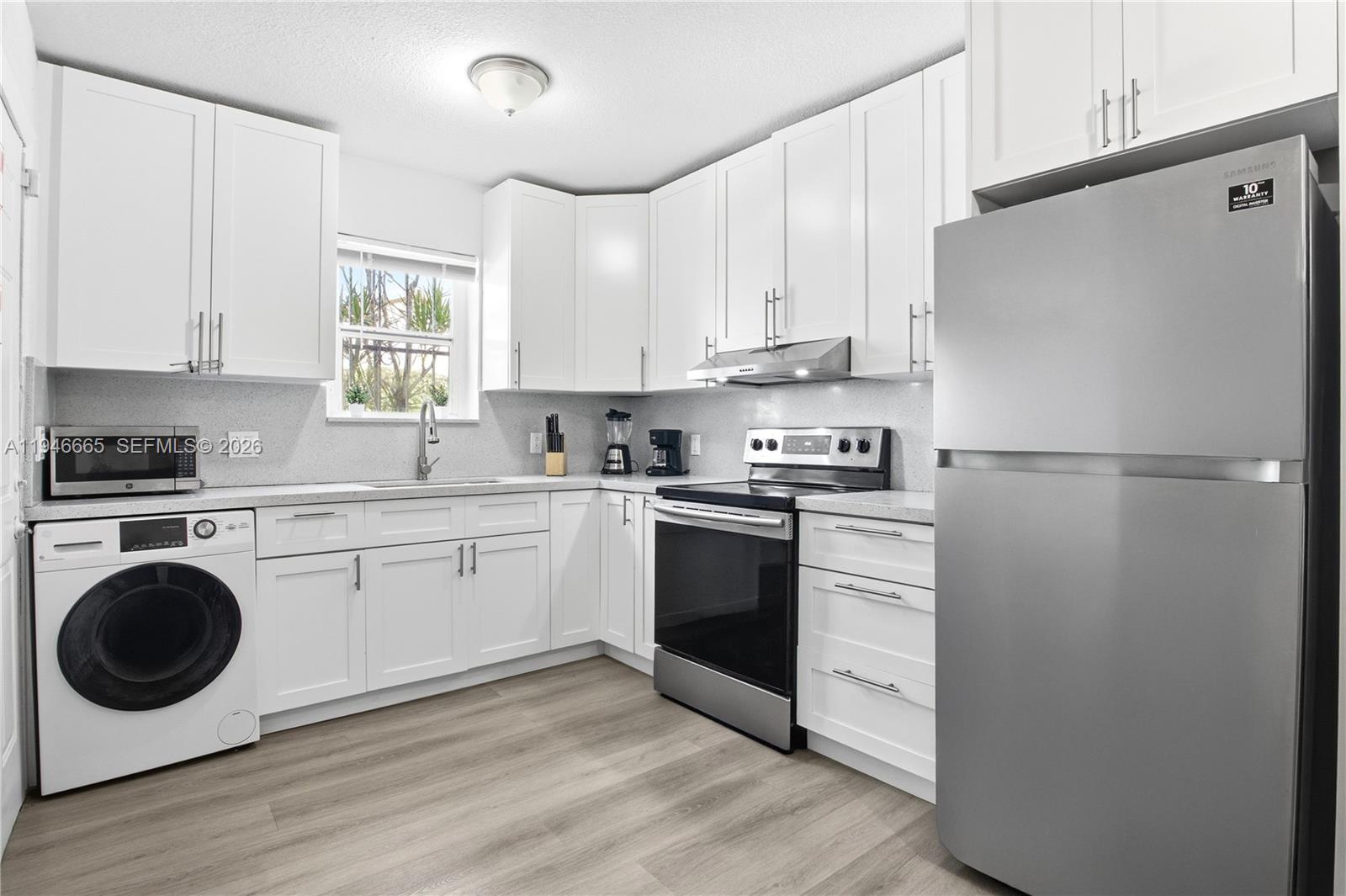 3318 Northwest 19th Avenue, Unit 1 Miami, FL 33142 - Photo 4 of 12 a kitchen with a refrigerator sink and cabinets