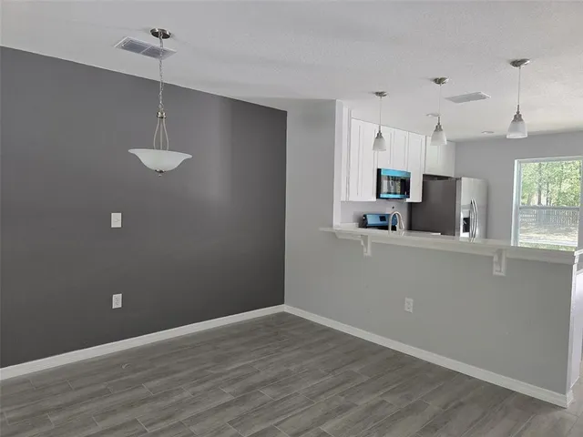 a kitchen with cabinets and wooden floor