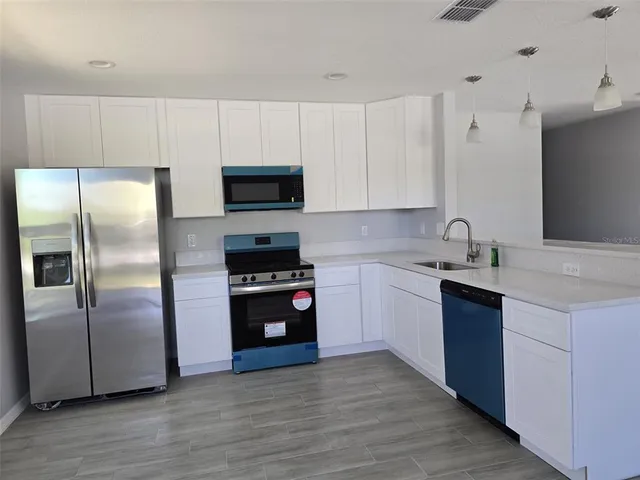 a kitchen with granite countertop a refrigerator and a sink