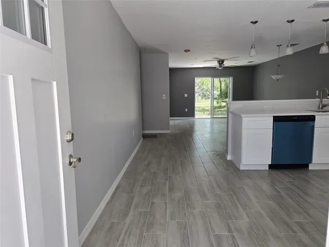 a view of a kitchen with wooden floor and a window