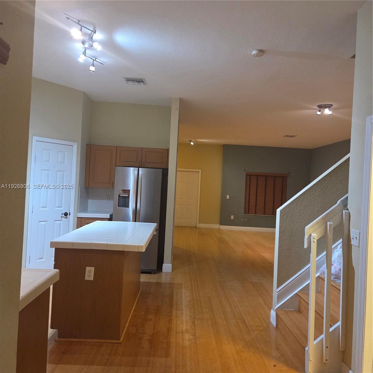 a view of a kitchen with a sink and dishwasher with wooden floor