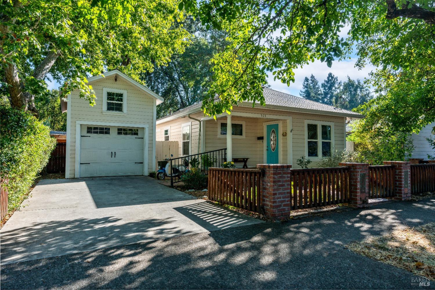 a view of a house with a yard and wooden fence