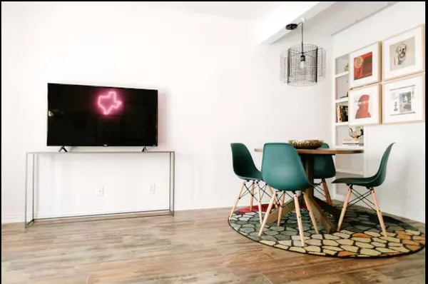 a living room with a flat screen tv and chairs