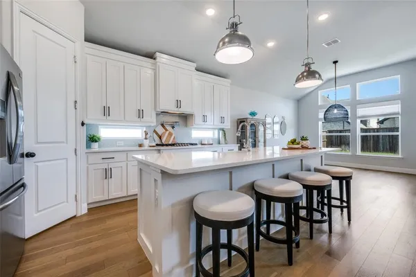 a kitchen with a sink cabinets and wooden floor