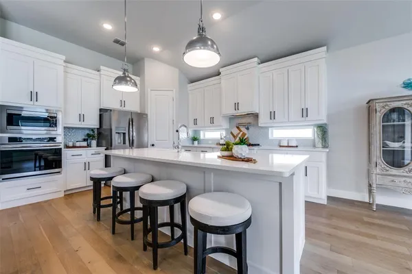 a kitchen with kitchen island granite countertop a sink cabinets and wooden floor