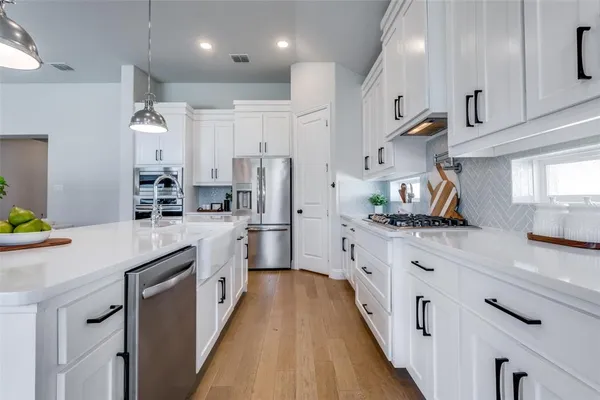 a kitchen with stainless steel appliances a sink stove and refrigerator