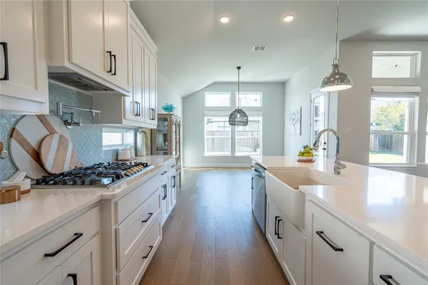 a kitchen with stainless steel appliances a sink stove and cabinets
