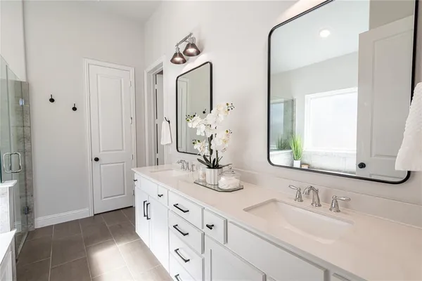 a bathroom with double vanity sinks and a mirror