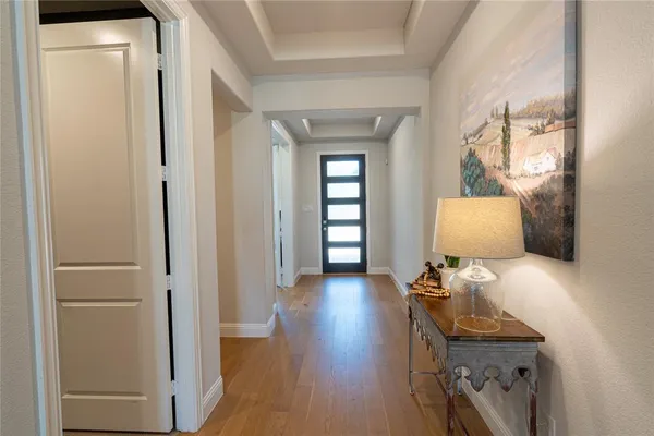 a view of a hallway with wooden floor and a living room