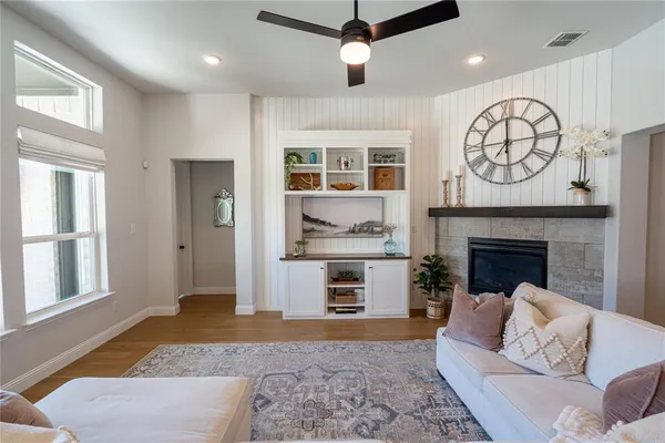 a living room with furniture a clock and a fireplace