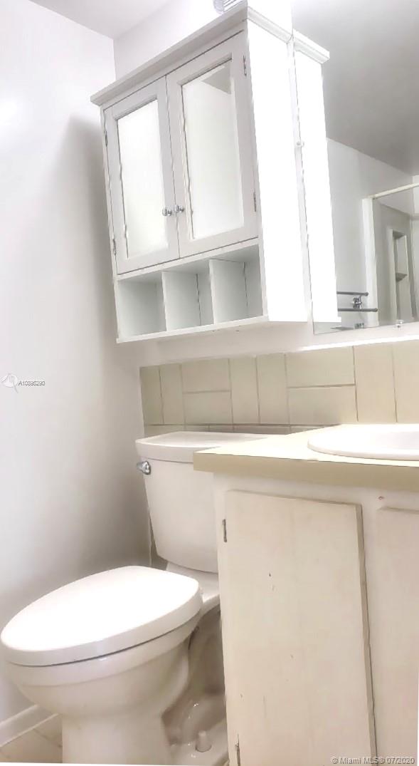2701 Riverside Drive, Unit 514B Coral Springs, FL 33065 - Photo 12 of 22 a bathroom with a toilet a sink and a mirror