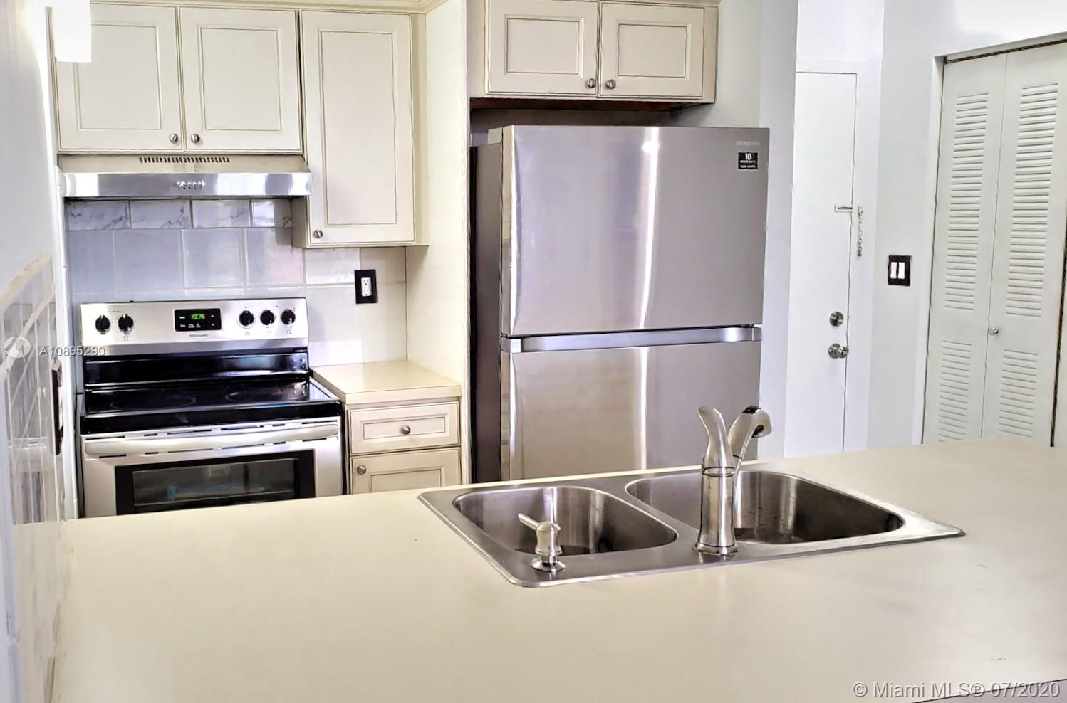 2701 Riverside Drive, Unit 514B Coral Springs, FL 33065 - Photo 2 of 22 a kitchen with a refrigerator sink and cabinets