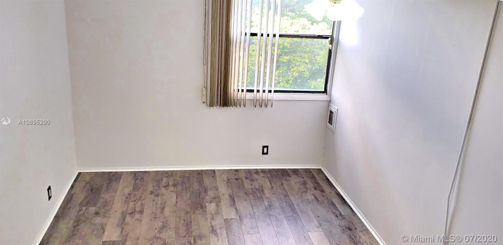 2701 Riverside Drive, Unit 514B Coral Springs, FL 33065 - Photo 9 of 22 a view of an empty room with wooden floor and a window