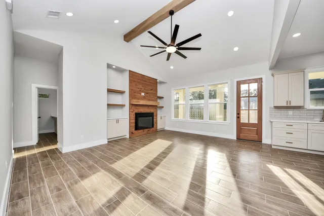 a view of an empty room with a fireplace and a window