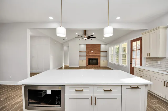 a large kitchen with white cabinets and stainless steel appliances