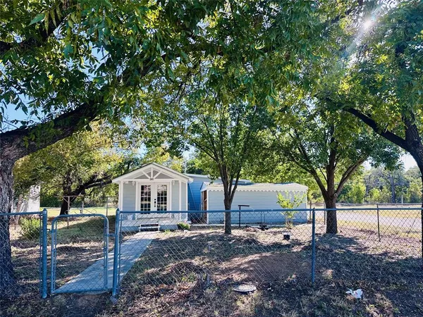 a front view of a house with a yard and tree