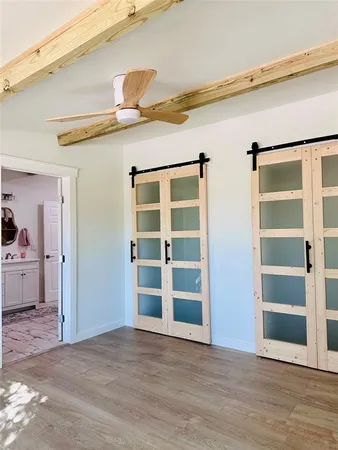 a view of a livingroom with wooden floor and a window