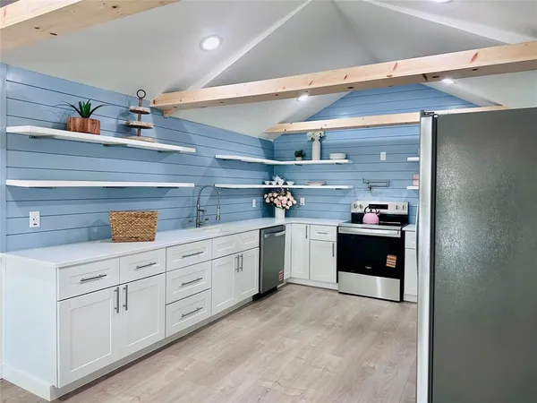 a kitchen with sink a stove and cabinets