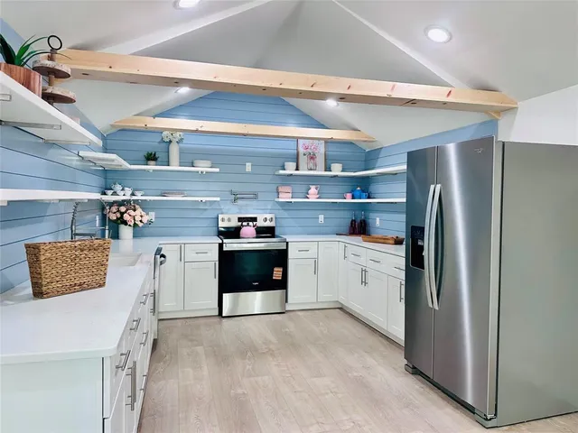 a kitchen with stainless steel appliances a refrigerator sink and stove
