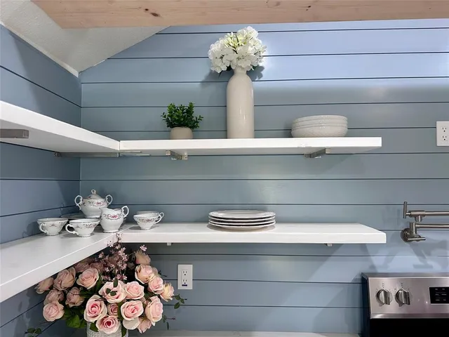 a vase of flowers sitting on a shelf