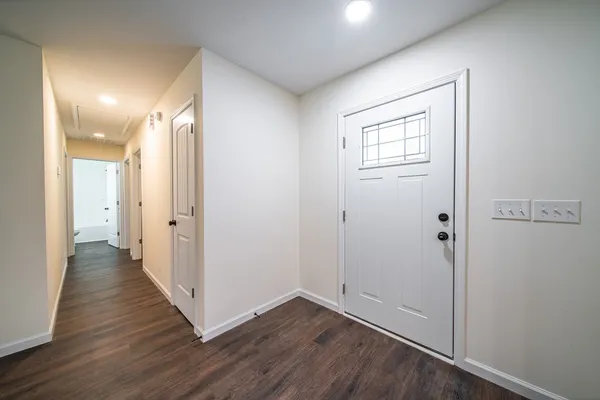 a view of a hallway with wooden floor