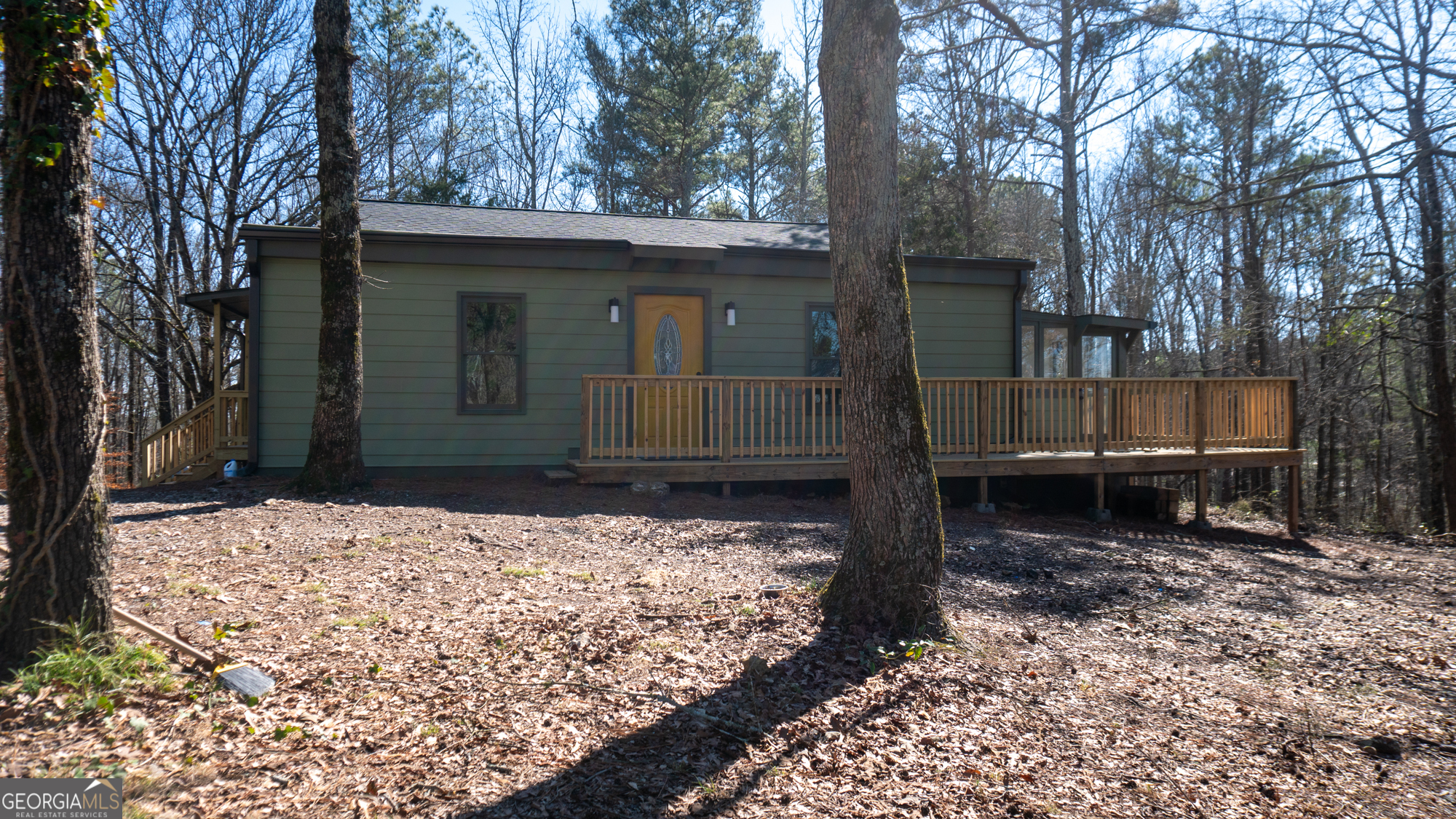 a view of a house with a yard and large tree