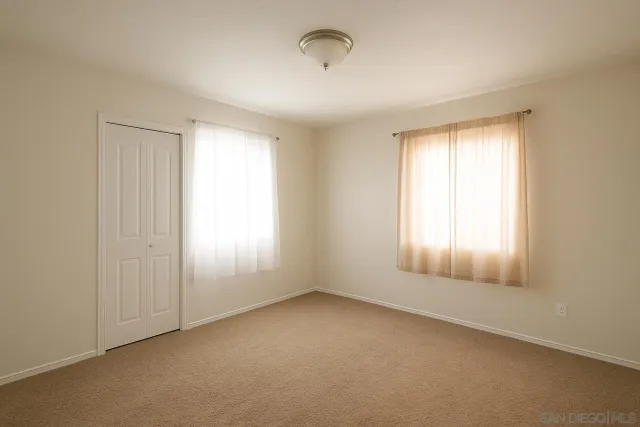 an empty room with windows and closet
