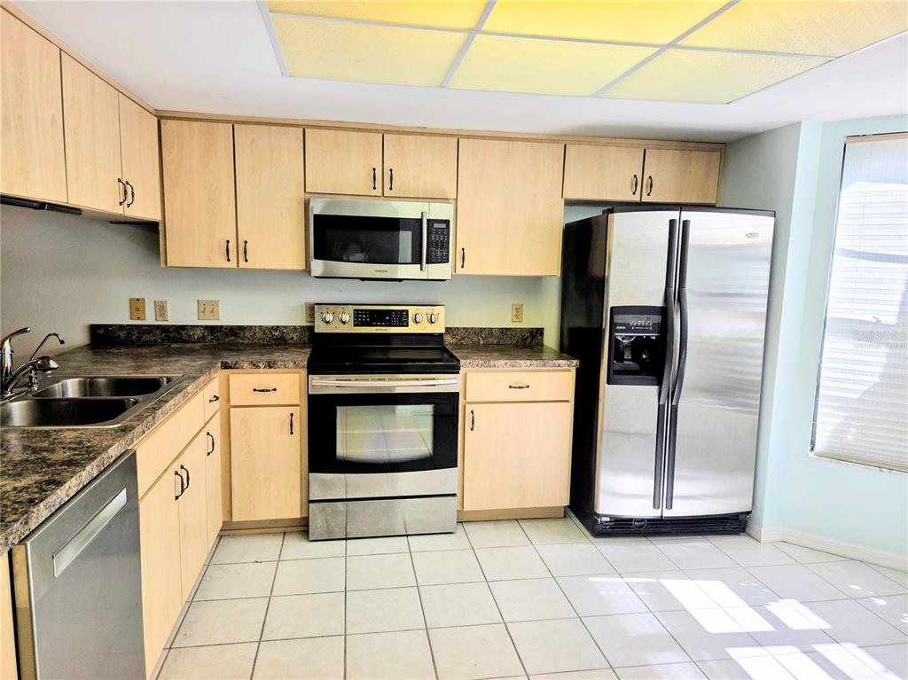 3239 Lori Lane, Unit 3239 New Port Richey, FL 34655 - Photo 5 of 33 a kitchen with a stove a sink and a refrigerator