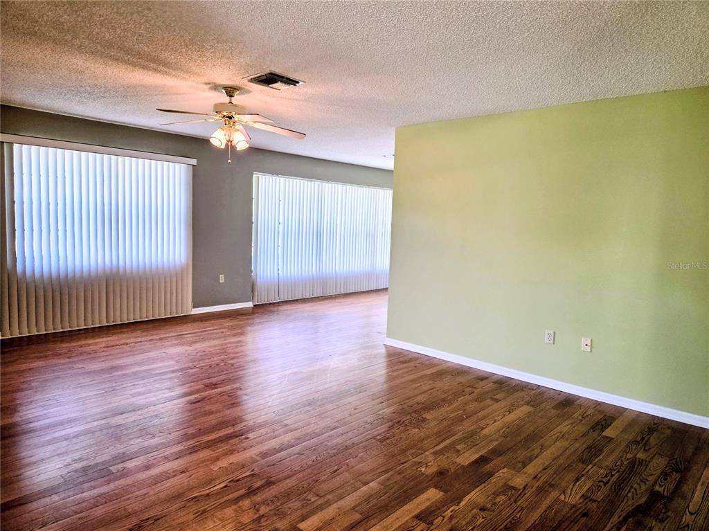 3239 Lori Lane, Unit 3239 New Port Richey, FL 34655 - Photo 6 of 33 a view of an empty room with wooden floor and a window