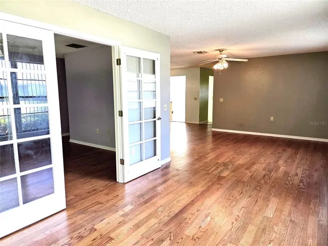 a view of a hallway with wooden floor and chandelier