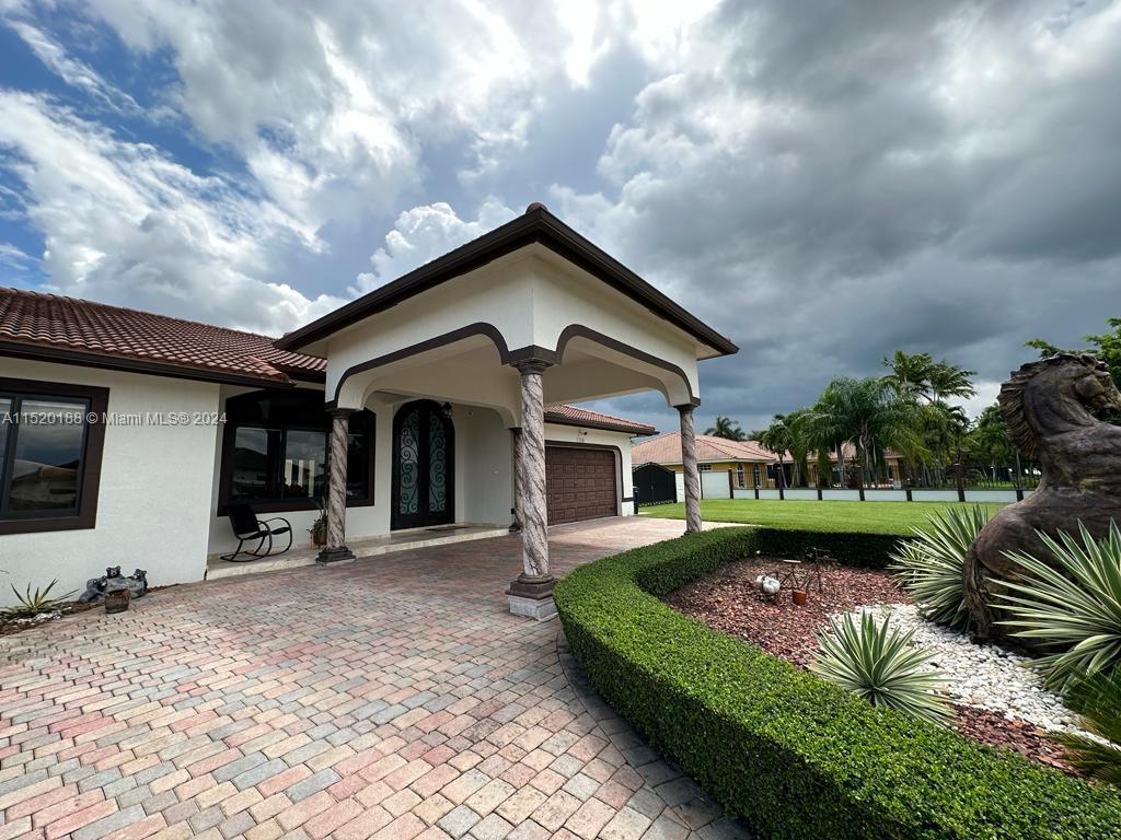 13430 Southwest 192nd Street Miami, FL 33177 - Photo 13 of 37 a front view of a house with garden