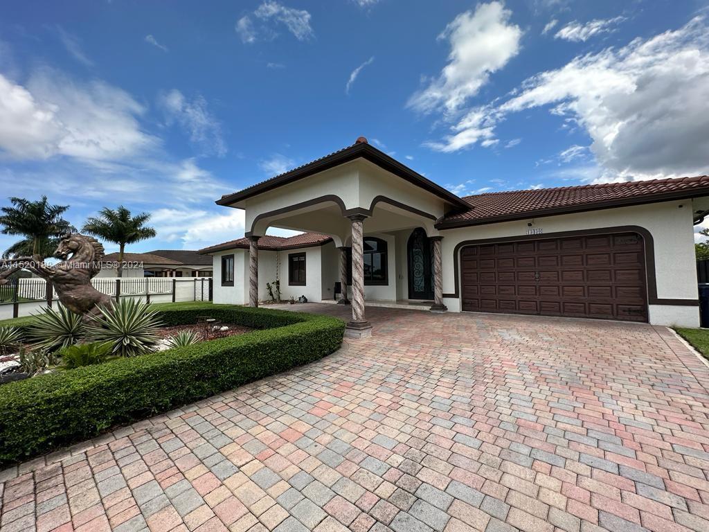 13430 Southwest 192nd Street Miami, FL 33177 - Photo 14 of 37 a front view of a house with a yard and garage