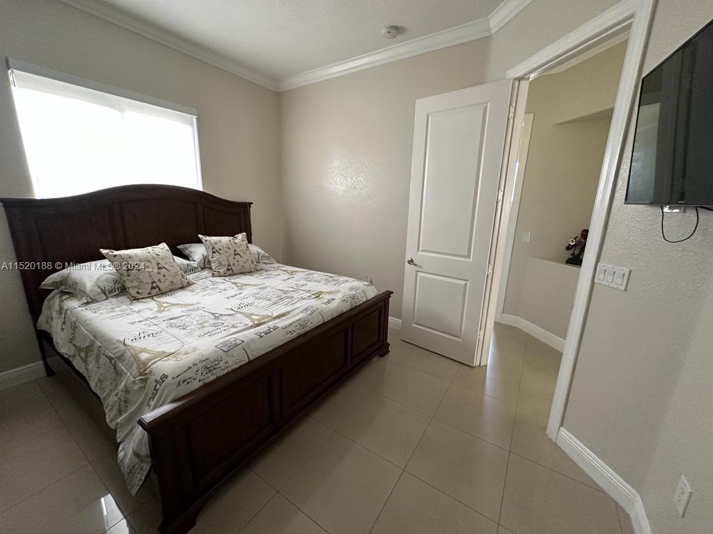 13430 Southwest 192nd Street Miami, FL 33177 - Photo 21 of 37 a bedroom with a bed and a large mirror