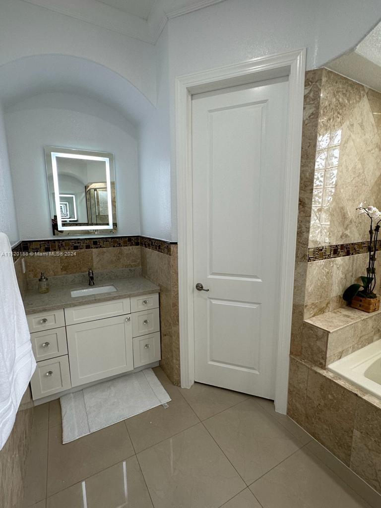 13430 Southwest 192nd Street Miami, FL 33177 - Photo 28 of 37 a spacious bathroom with a granite countertop sink and a mirror