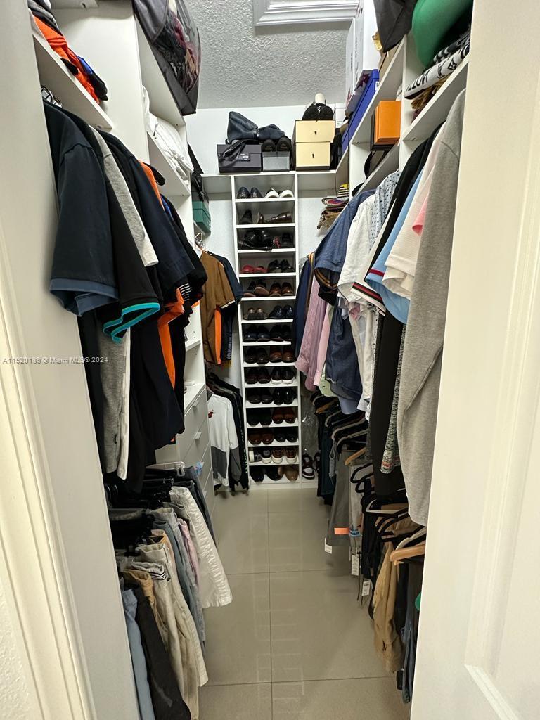 13430 Southwest 192nd Street Miami, FL 33177 - Photo 32 of 37 a view of walk in closet with clothes and shoes