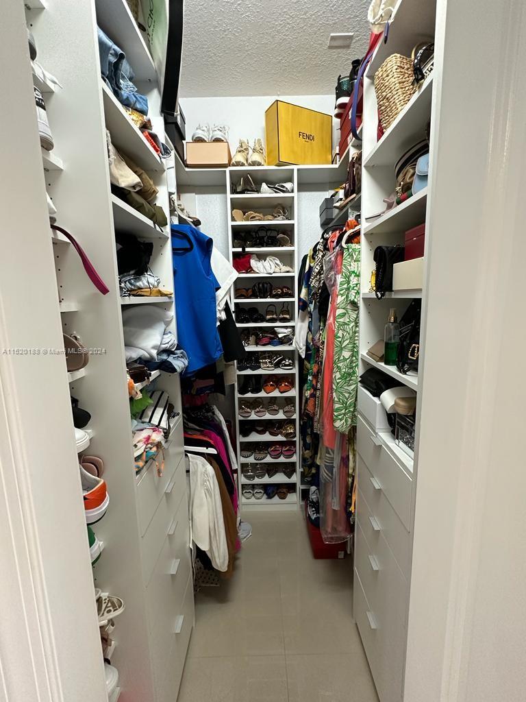 13430 Southwest 192nd Street Miami, FL 33177 - Photo 34 of 37 a view of walk in closet with clothes and shoes