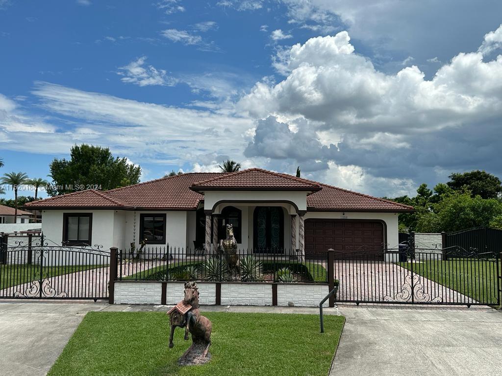 13430 Southwest 192nd Street Miami, FL 33177 - Photo 6 of 37 a front view of a house with a garden and yard