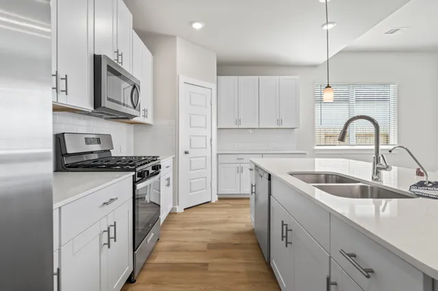 a view of an empty room with wooden floor and windows
