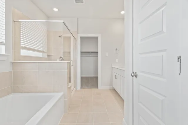 a spacious bathroom with a double vanity sink a mirror and a shower