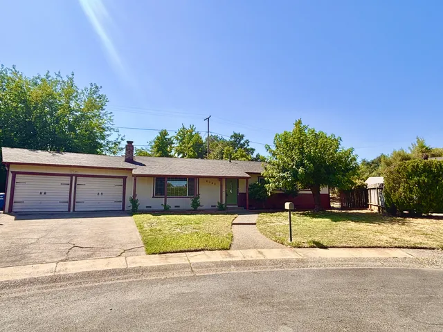 a view of a house with a yard and potted plants