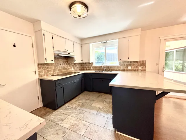 a kitchen with a sink window and cabinets