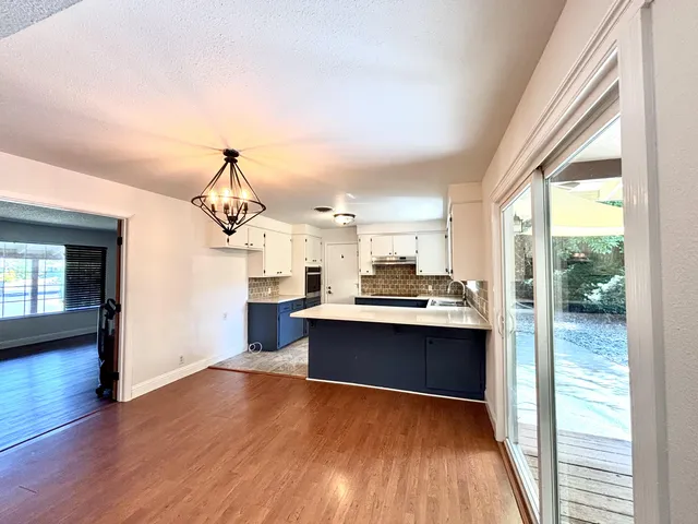 a view of a kitchen with wooden floor and electronic appliances